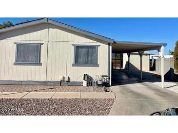 Tan single-wide manufactured home with carport and paved driveway at 11275 N 99Th Ave # 7, Peoria, AZ 85345