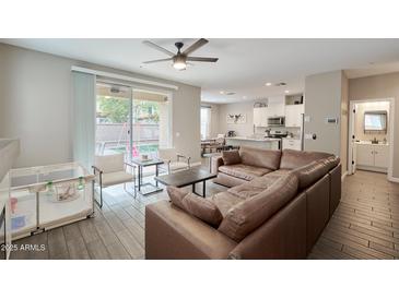 Spacious living room with brown leather sectional sofa and access to backyard at 1255 N Arizona Ave # 1148, Chandler, AZ 85225