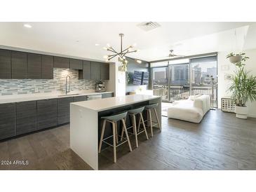 Modern kitchen with island, stainless steel appliances, and stylish backsplash at 200 W Portland St # 715, Phoenix, AZ 85003