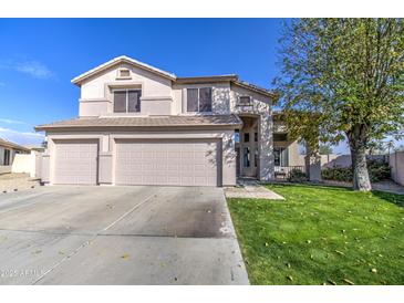 Two-story house with three-car garage and manicured lawn at 20997 N 79Th Ave, Peoria, AZ 85382