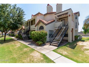 Two-story condo building with a walkway, landscaping, and stairs at 2333 E Southern Ave # 2041, Tempe, AZ 85282