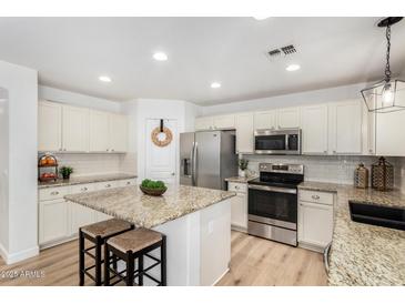 Bright kitchen with granite island, stainless steel appliances, and white shaker cabinets at 3984 E Los Altos Dr, Gilbert, AZ 85297