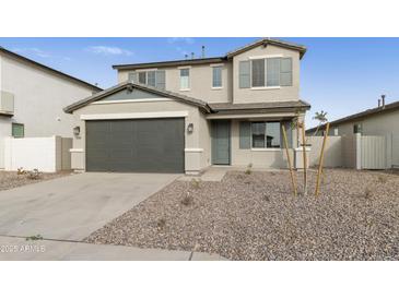 Two-story house with gray siding, a two-car garage, and a landscaped front yard at 5018 W Walatowa St, Laveen, AZ 85339