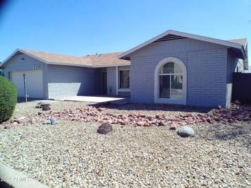 Single-story home with gray exterior, landscaped yard, and a two-car garage at 5843 W Crocus Dr, Glendale, AZ 85306