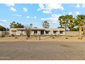 White single story home with landscaped yard and driveway at 5960 E Pershing Ave, Scottsdale, AZ 85254