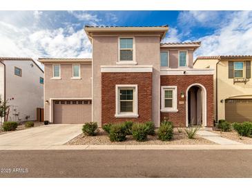 Two-story home with brick and stucco exterior, attached garage, and landscaping at 646 S Jacana Ln, Gilbert, AZ 85296