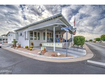 Inviting exterior of a manufactured home with landscaped yard and covered porch at 7750 E Broadway Rd # 584, Mesa, AZ 85208