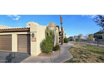 Building exterior showcasing Spanish-style architecture, landscaping, and a walkway at 8344 N 21St Dr # I212, Phoenix, AZ 85021