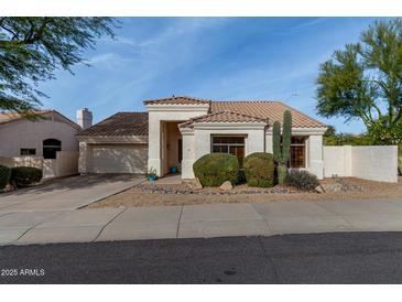 Single-story home with a two-car garage and desert landscaping at 9880 E Pine Valley Rd, Scottsdale, AZ 85260