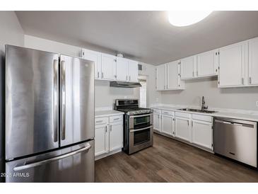 Updated kitchen with stainless steel appliances and white cabinets at 1022 S Lola Ln, Tempe, AZ 85281