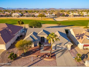 Aerial view of a house and neighborhood with a golf course nearby at 13708 W Robertson Dr, Sun City West, AZ 85375