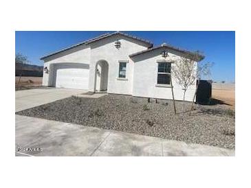 New construction home with a two-car garage and desert landscaping at 18950 W Stella Ave, Waddell, AZ 85355