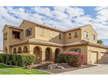 Two-story house with a large front yard, landscaping, and a three-car garage at 21525 E Camacho Rd, Queen Creek, AZ 85142