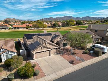 Stunning front view of desert home featuring solar panels, spacious driveway, 2-car garage, and landscaped front yard at 3727 N Kings Peak N Cir, Mesa, AZ 85215