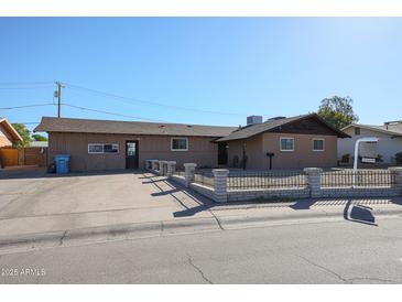 Ranch style home with a well-maintained front yard, featuring a small fence at 4131 N 55Th Dr, Phoenix, AZ 85031