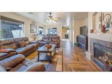 Spacious living room with a fireplace and hardwood floors at 43568 W Bedford Dr, Maricopa, AZ 85138