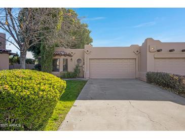 Tan stucco house with a two-car garage and nicely landscaped front yard at 5777 N 78Th Pl, Scottsdale, AZ 85250