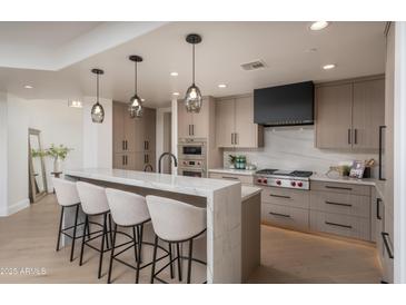 Beautiful kitchen featuring a quartz island with seating, stainless steel appliances, and modern cabinetry at 7175 E Camelback Rd # 601, Scottsdale, AZ 85251