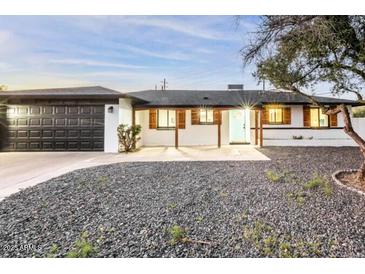 Updated mid-century modern home with dark gray garage door and light-colored exterior at 1720 W Sunnyslope Ln, Phoenix, AZ 85021