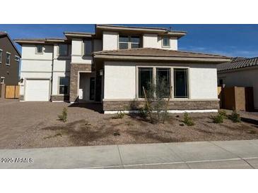 Two-story home with stone and light-colored siding, attached garage, and landscaping at 17832 W Medlock Dr, Litchfield Park, AZ 85340