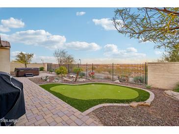 Landscaped backyard featuring a putting green, hot tub, and expansive views at 2317 N Beverly Pl, Buckeye, AZ 85396
