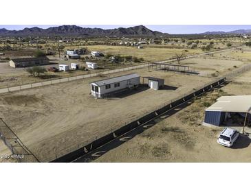 Expansive lot featuring a charming single-story home with metal roof and convenient outdoor storage at 6326 N Deer Trl, Maricopa, AZ 85139