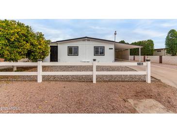 Updated manufactured home with carport and white fence at 1031 S 98Th St, Mesa, AZ 85208