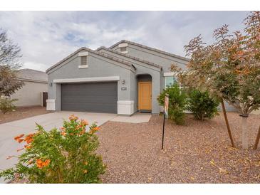 Gray house with a two-car garage and landscaping at 18972 W Woodlands Ave, Buckeye, AZ 85326