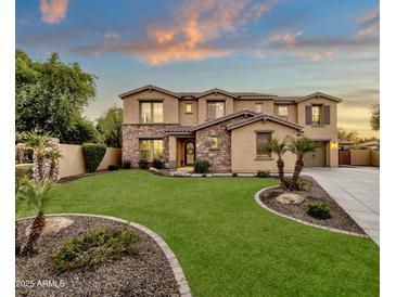 Two-story house with stone accents, landscaped lawn, and a three-car garage at 3829 E Sawtooth Dr, Chandler, AZ 85249