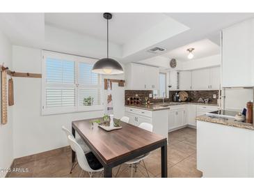 Bright kitchen with granite counters and white cabinets at 4444 E Paradise Village N Pkwy # 107, Phoenix, AZ 85032