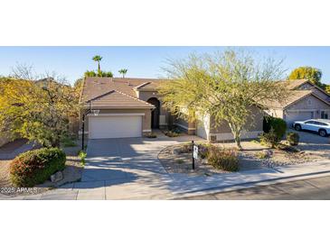 Single-story home with a two-car garage and desert landscaping at 9754 E Natal Ave, Mesa, AZ 85209