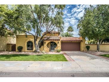 Spanish style home with landscaped yard and two-car garage at 10473 N 87Th Pl, Scottsdale, AZ 85258