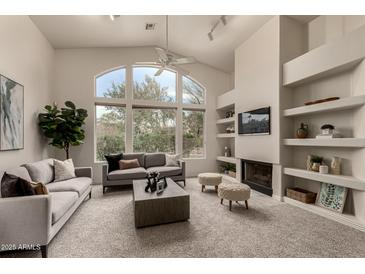 Spacious living room with vaulted ceilings, fireplace, and large windows at 11664 E Caron St, Scottsdale, AZ 85259