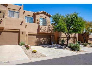 Tan two-story townhome with two-car garage and desert landscaping at 11683 N 135Th Pl, Scottsdale, AZ 85259