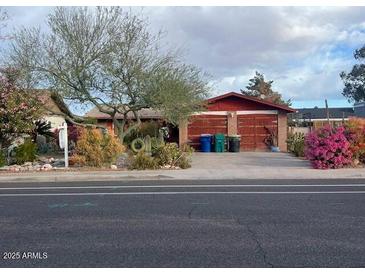 Charming single-story home with a well-manicured front yard and attached garage at 1232 E Mclellan Rd, Mesa, AZ 85203