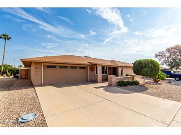 Tan single story house with a two-car garage and landscaped yard at 13438 W Ashwood Dr, Sun City West, AZ 85375