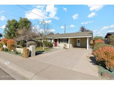 Ranch style home with a large driveway and well-manicured lawn at 1374 W 16Th St, Tempe, AZ 85281