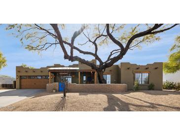 Spanish-style home with wood accents and a large tree in the front yard at 17203 E Calaveras Ave, Fountain Hills, AZ 85268