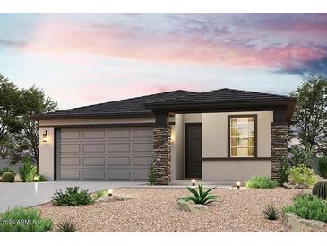 One-story home with gray siding, stone accents, and a two-car garage at 18228 W Daley Ln, Surprise, AZ 85387