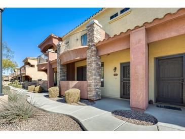 Attractive exterior of a two-story townhome with stone accents and a walkway at 21655 N 36Th Ave # 106, Glendale, AZ 85308