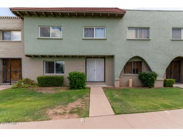 Light green stucco exterior of a townhome with a well-manicured lawn at 225 N Standage -- # 122, Mesa, AZ 85201