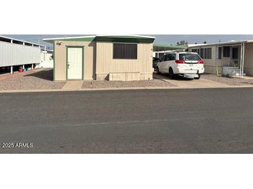 Tan mobile home with green trim, and a carport at 300 S Val Vista Dr # 77, Mesa, AZ 85204