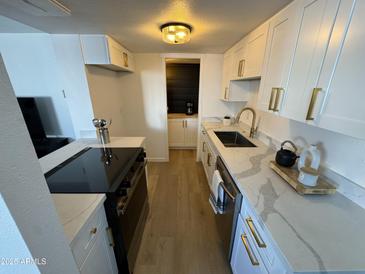 Modern kitchen with white cabinets, quartz countertops, and stainless steel appliances at 5238 N 42Nd Ln, Phoenix, AZ 85019