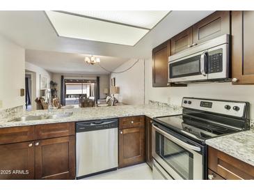 Modern kitchen features stainless steel appliances and granite countertops at 534 S Palo Verde Way, Mesa, AZ 85208