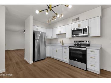 Updated kitchen with stainless steel appliances and white shaker cabinets at 5921 W Hearn Rd, Glendale, AZ 85306