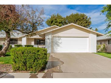 Single story home with attached garage, landscaping, and large driveway at 12510 W Brandywine Dr, Sun City West, AZ 85375