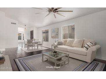 Virtually staged living area featuring hardwood floors, a dining area, and ample natural light at 16019 S 40Th Way, Phoenix, AZ 85048