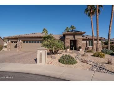 Single-story home with stone accents and a three-car garage at 19941 N Summer Dream Dr, Surprise, AZ 85374