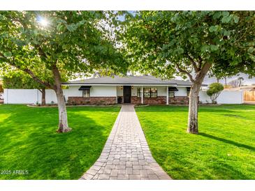 Ranch house with mature trees, brick facade, and a stone pathway at 4017 E Wilshire Dr, Phoenix, AZ 85008