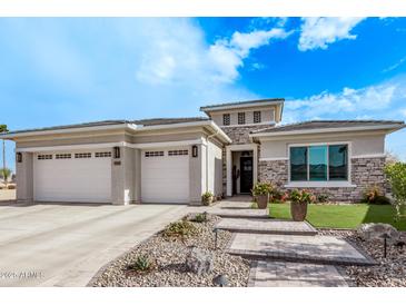 Single-story home with three-car garage, stone accents, and landscaped front yard at 5645 N Crow Dr, Eloy, AZ 85131